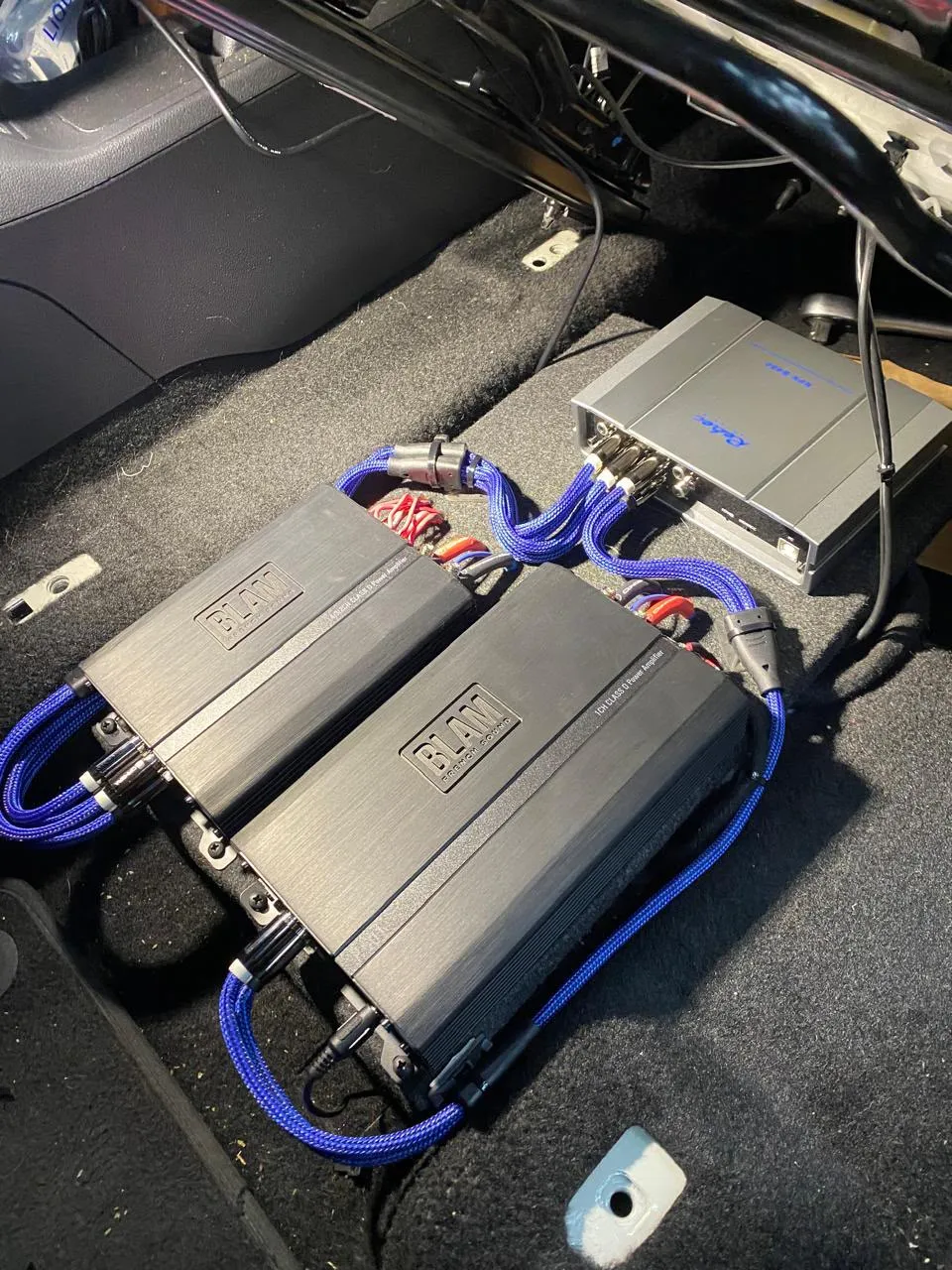 Dois amplificadores BLAM com cabos azuis trançados e processador de áudio Rebec