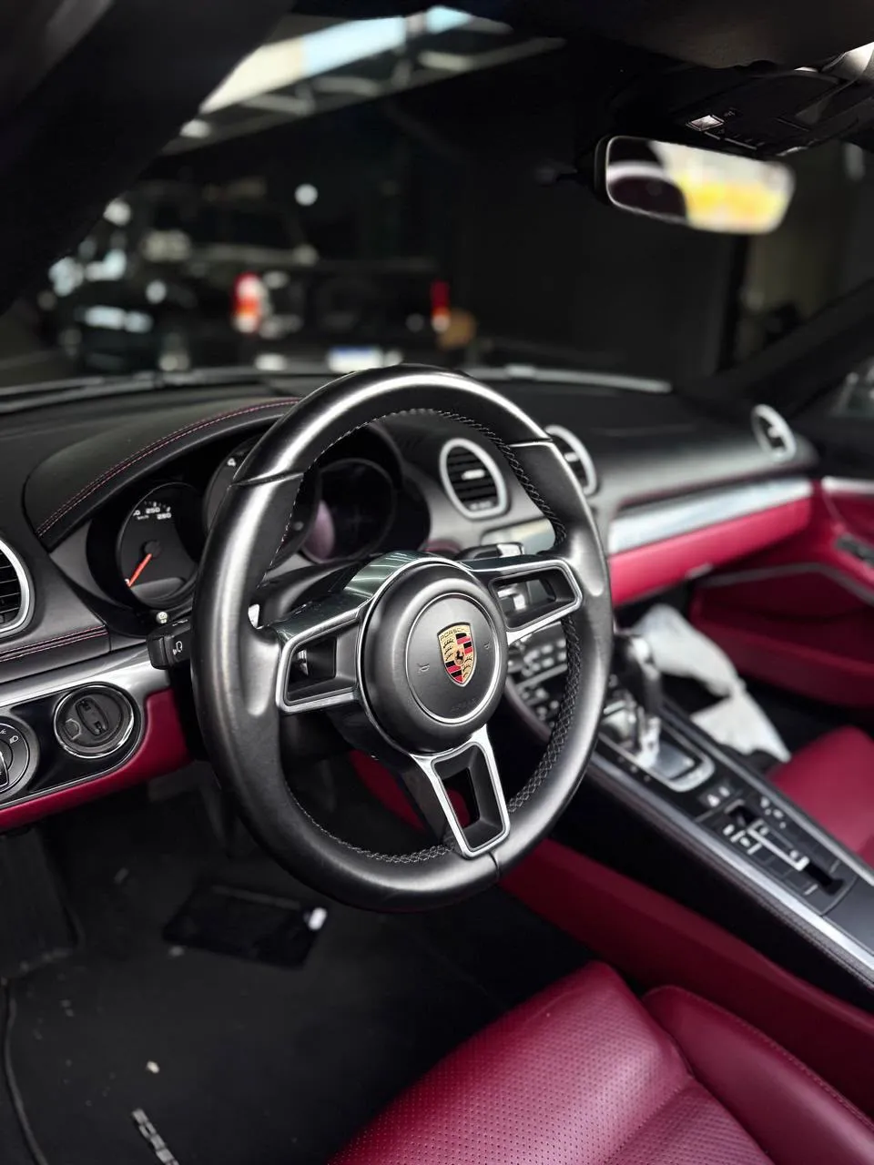 Interior de Porsche com volante e bancos em couro vermelho