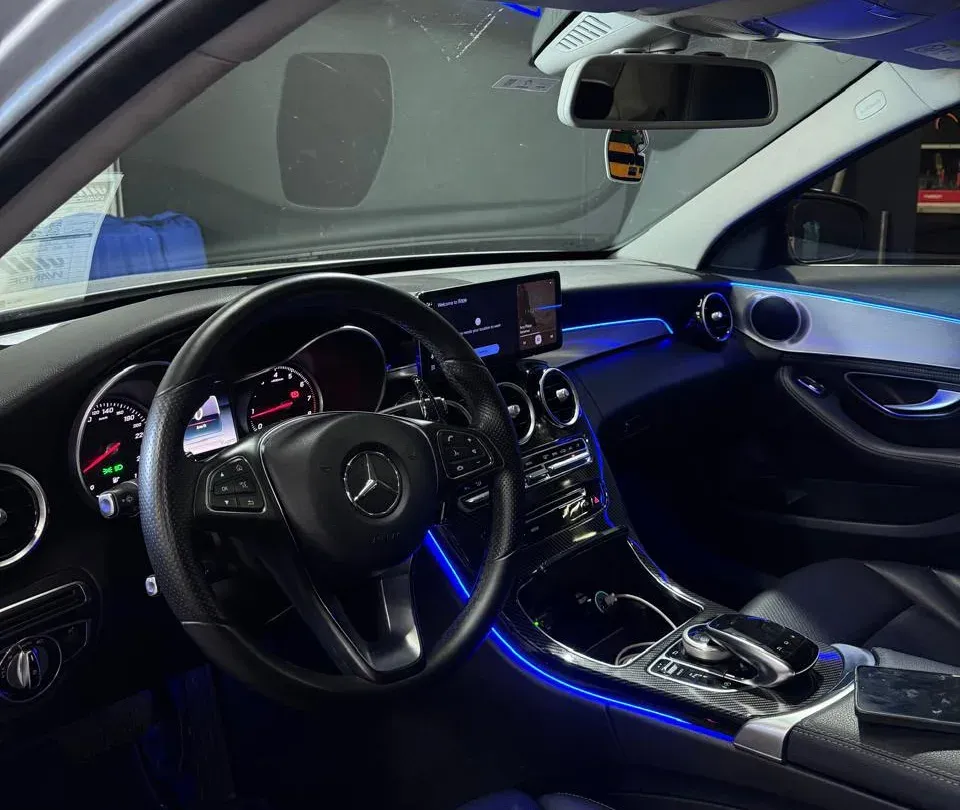 Interior de Mercedes-Benz com iluminação ambiente azul no painel, no console e na porta